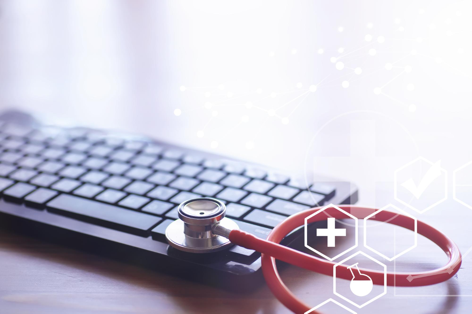 Stethoscope on a keyboard with a data trend overlay, representing predictive healthcare analytics
